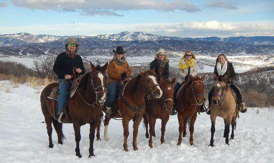 Saddleback Ranch horseback riders in wintertime posing for a photo