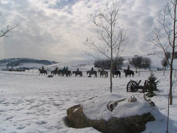 Saddleback Ranch horseback riders in the distance in the wintertime