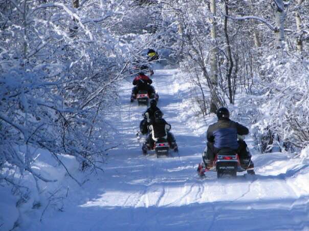 Snowmobiling Tour in the woods by Saddleback Ranch