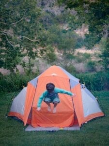 Camping with Kids Checklist Child Jumping in Tent