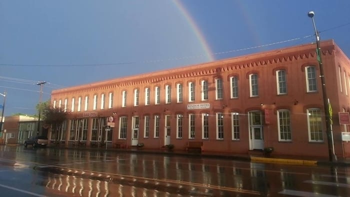 Exterior of the Windsor Hotel in Del Norte with a rainbow over it