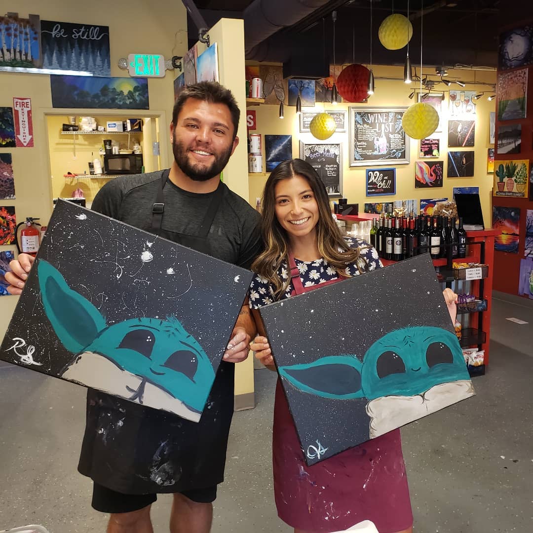 Image of two people holding there baby Yoda paintings from Painting with a Twist in Fort Collins, Colorado