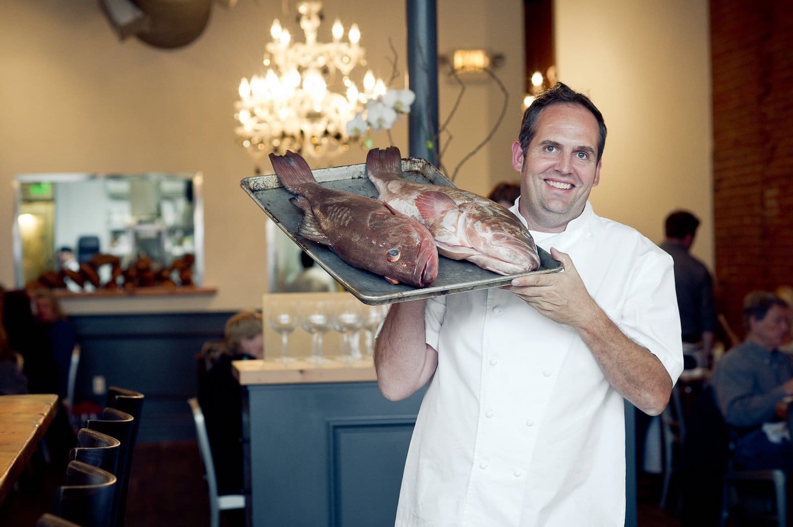 Image of a chef holding fish at The Kitchen American Bistro in Boulder, Colorado