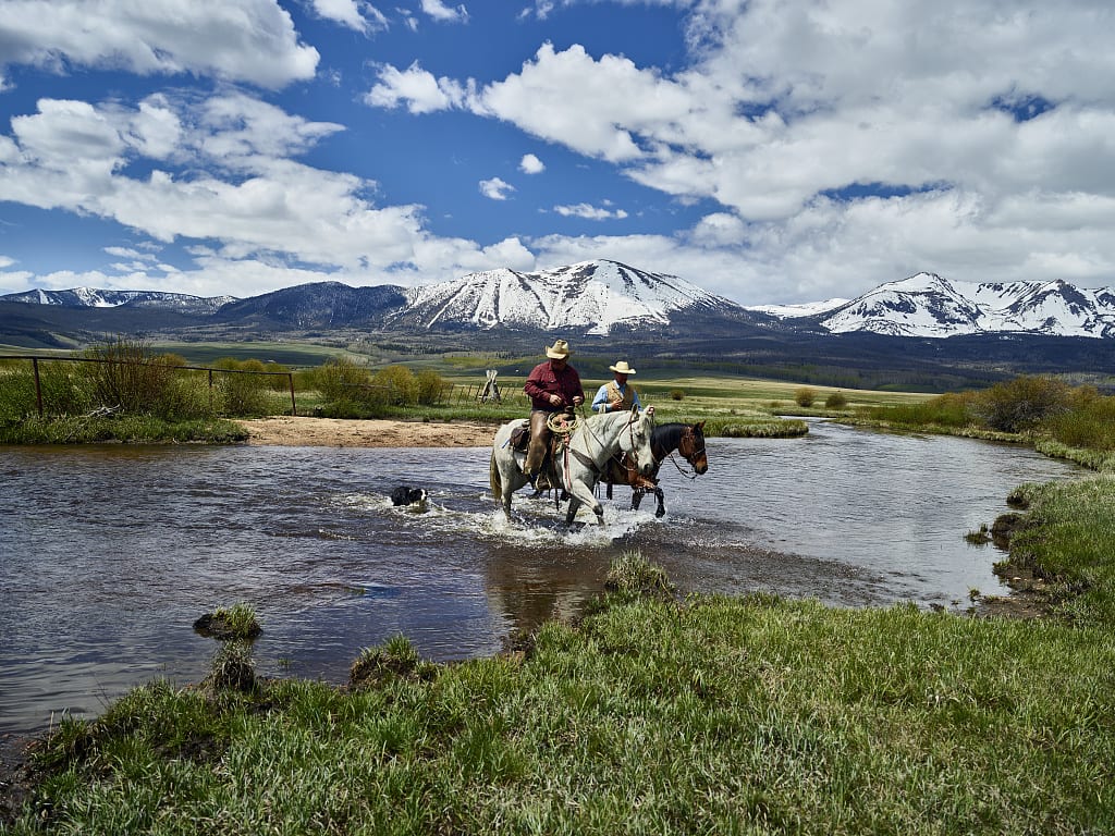 Cowboys on Horseback Cross North Platte River in North Park Colorado