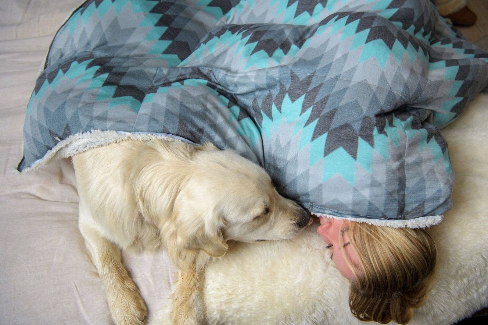 Image of a woman snuggling with her dog in a Holden & Hay weighted blanket