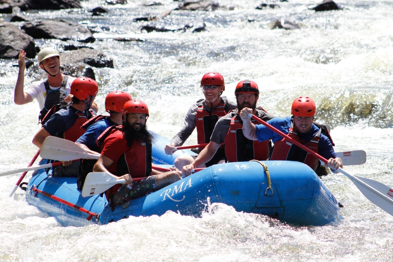 Image of 6 men whitewater rafting on cache la-poudre river in colorado