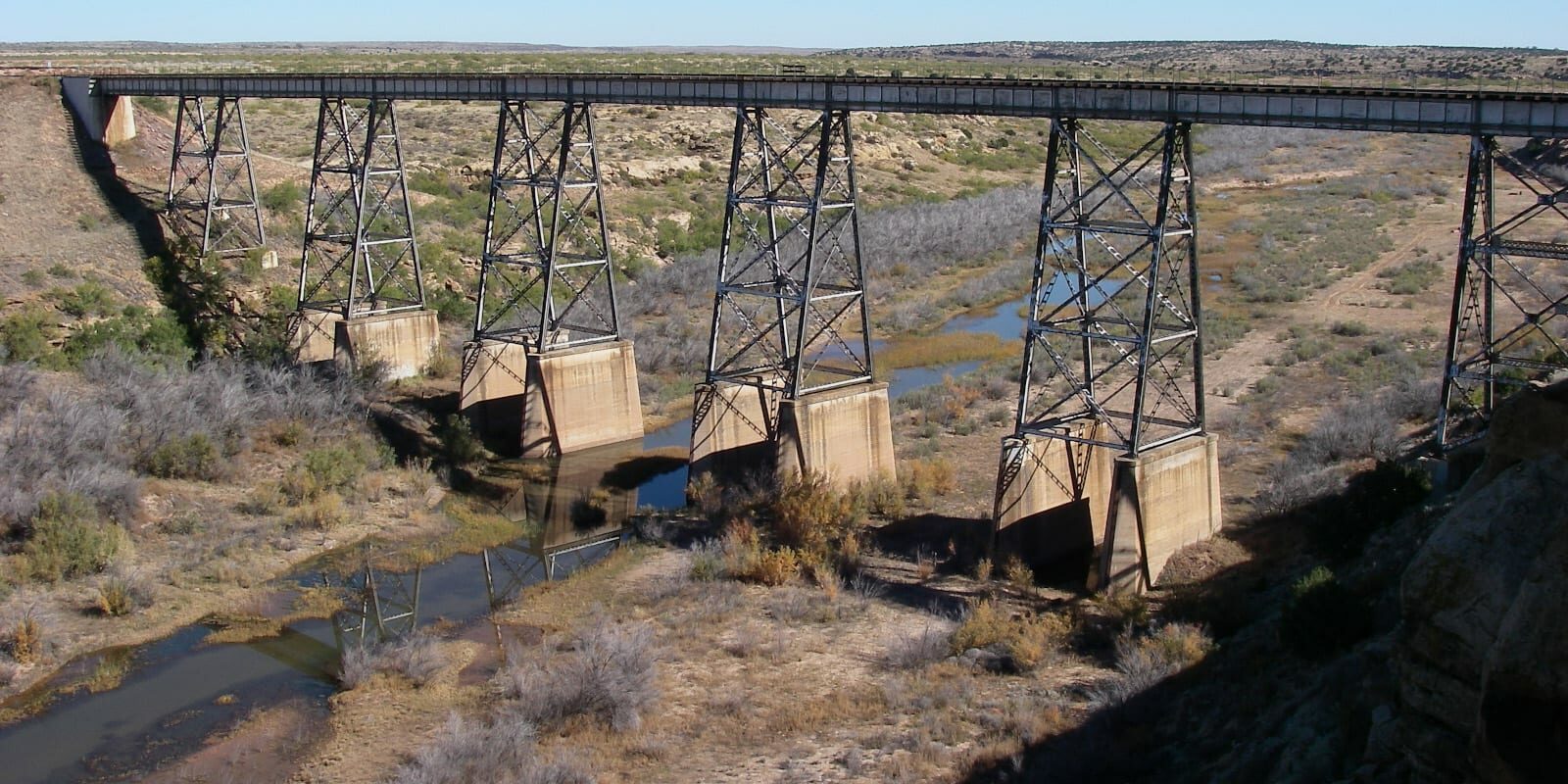 Image of the Canadian River in New Mexico with a railroad bridge crossing over