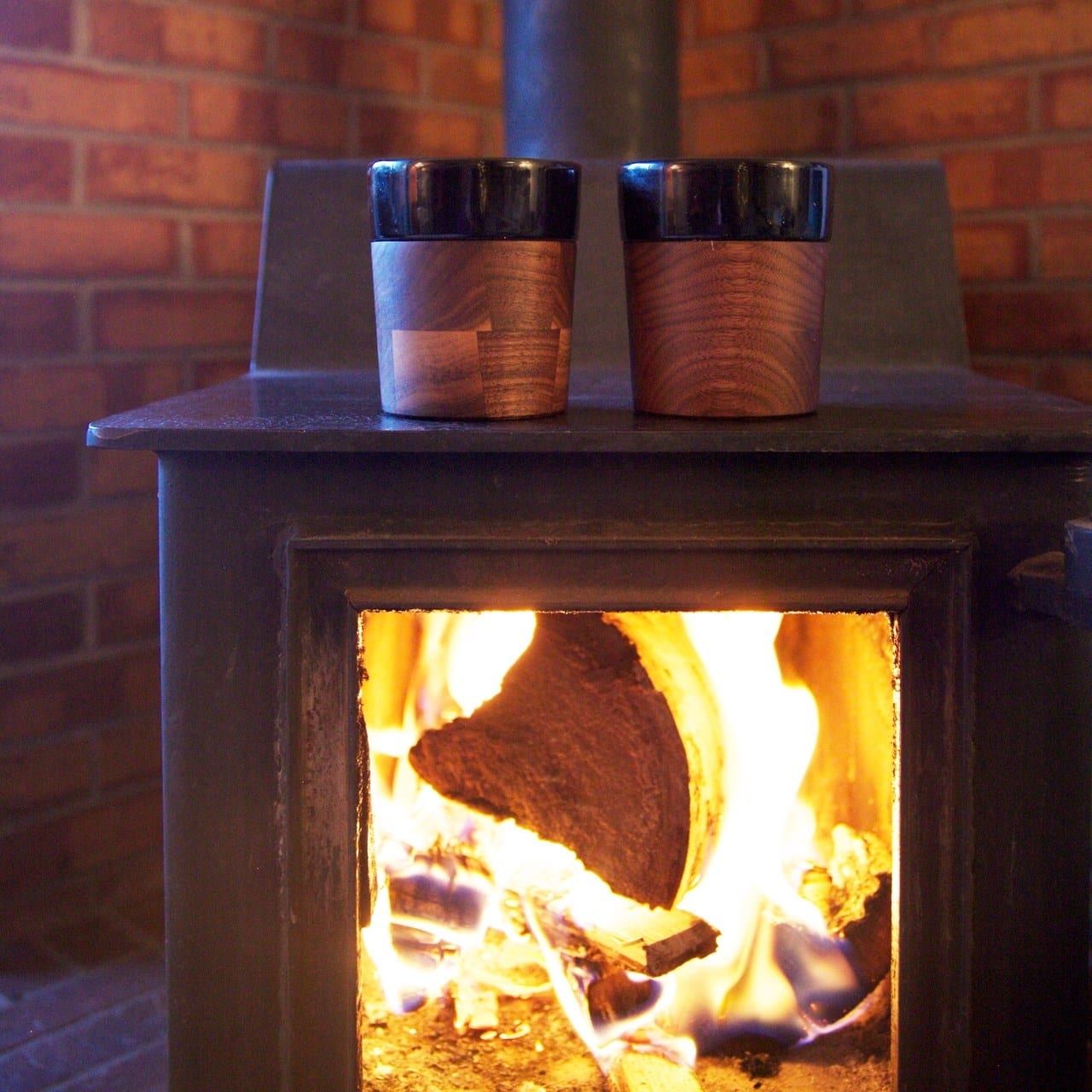 Image of two David Rasmussen wooden cups over a fireplace