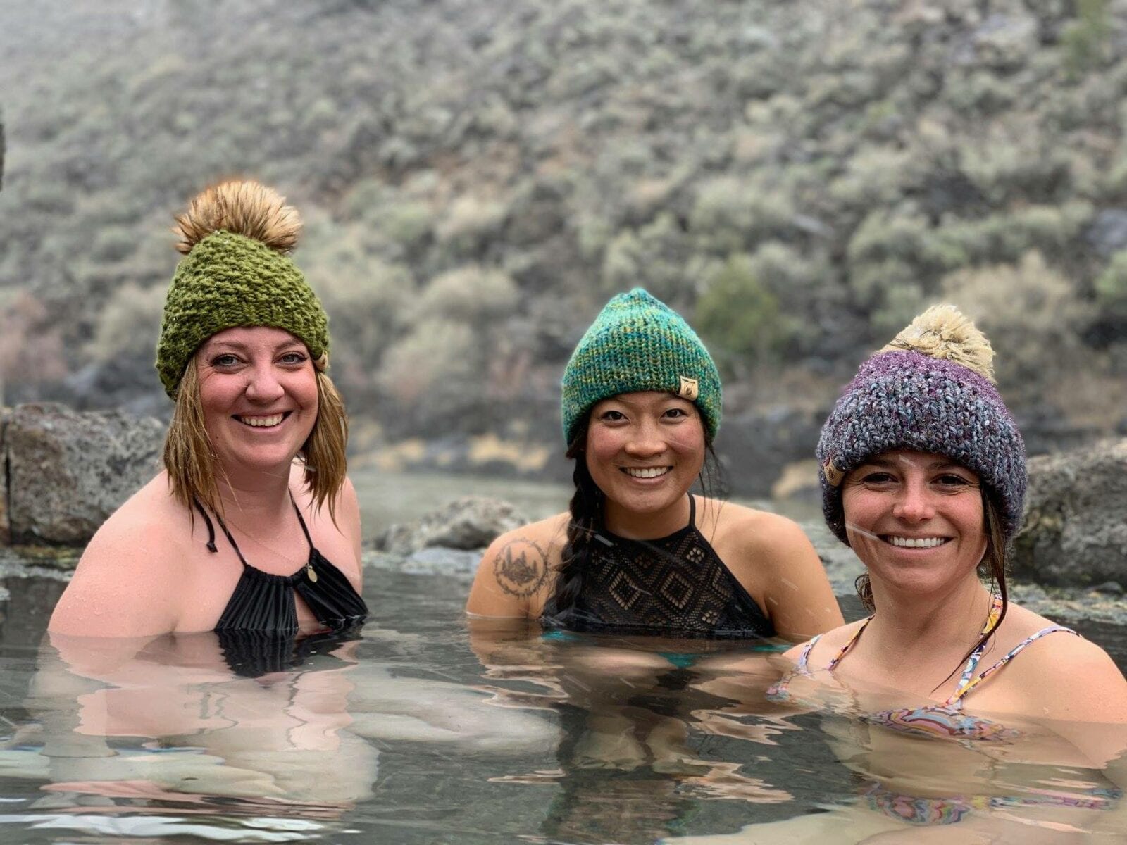 Image of three woman soaking in a hot spring in Colorado wearing Smeeny Beanie Knit hats