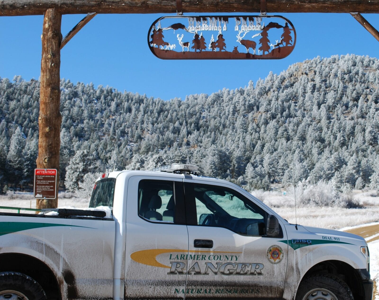 Image of a ranger car in front of the Hermit Park sign in Estes Park, Colorado