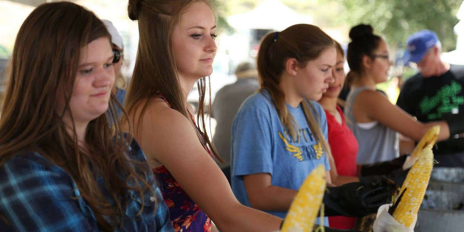 Image of girls running a corn stand at the Olathe Sweet Corn Festival in Colorado