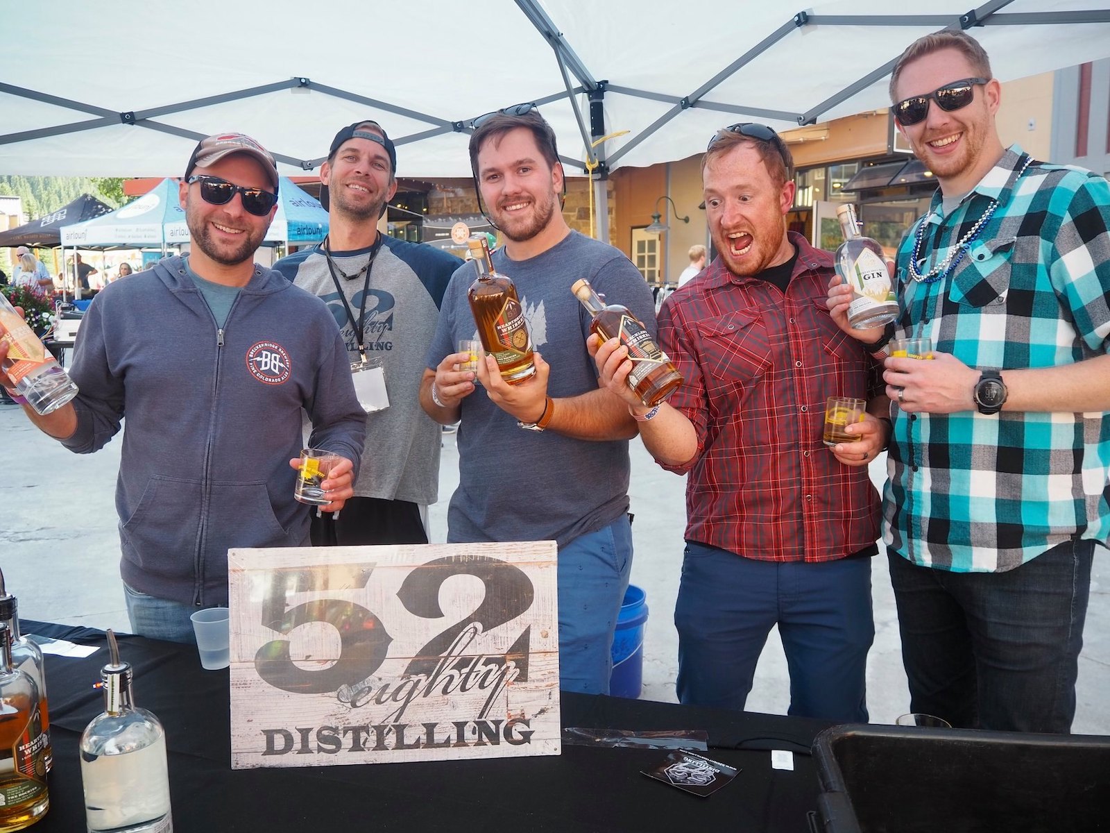 Image of a group of men at the 52 Eighty Distilling booth at Breckenridge Hogfest in Colorado