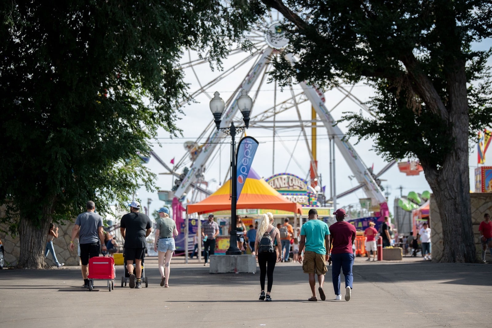 Image of people walking towards to the Ferris Wheel at the Colorado State Fair