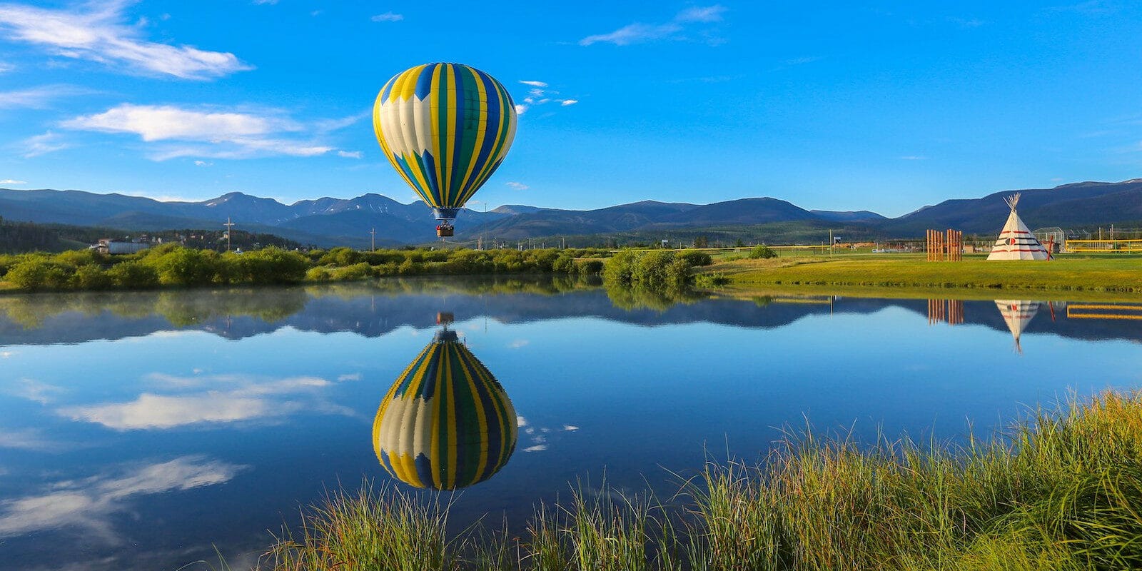 Image of a Grand Adventures Balloon Tours hot air balloon over water in Fraser, Colorado