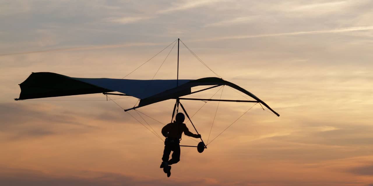 Image of a person hang gliding during sunset