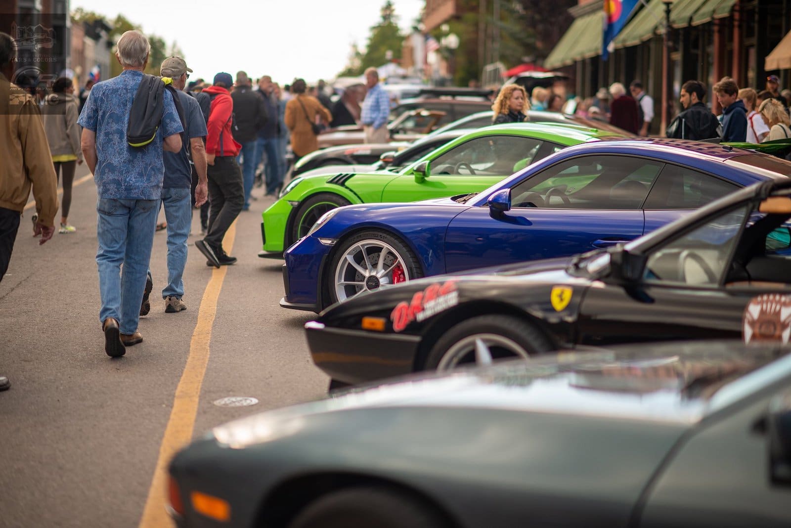 Image of people strolling past cars at the Telluride Autumn Classic in Colorado