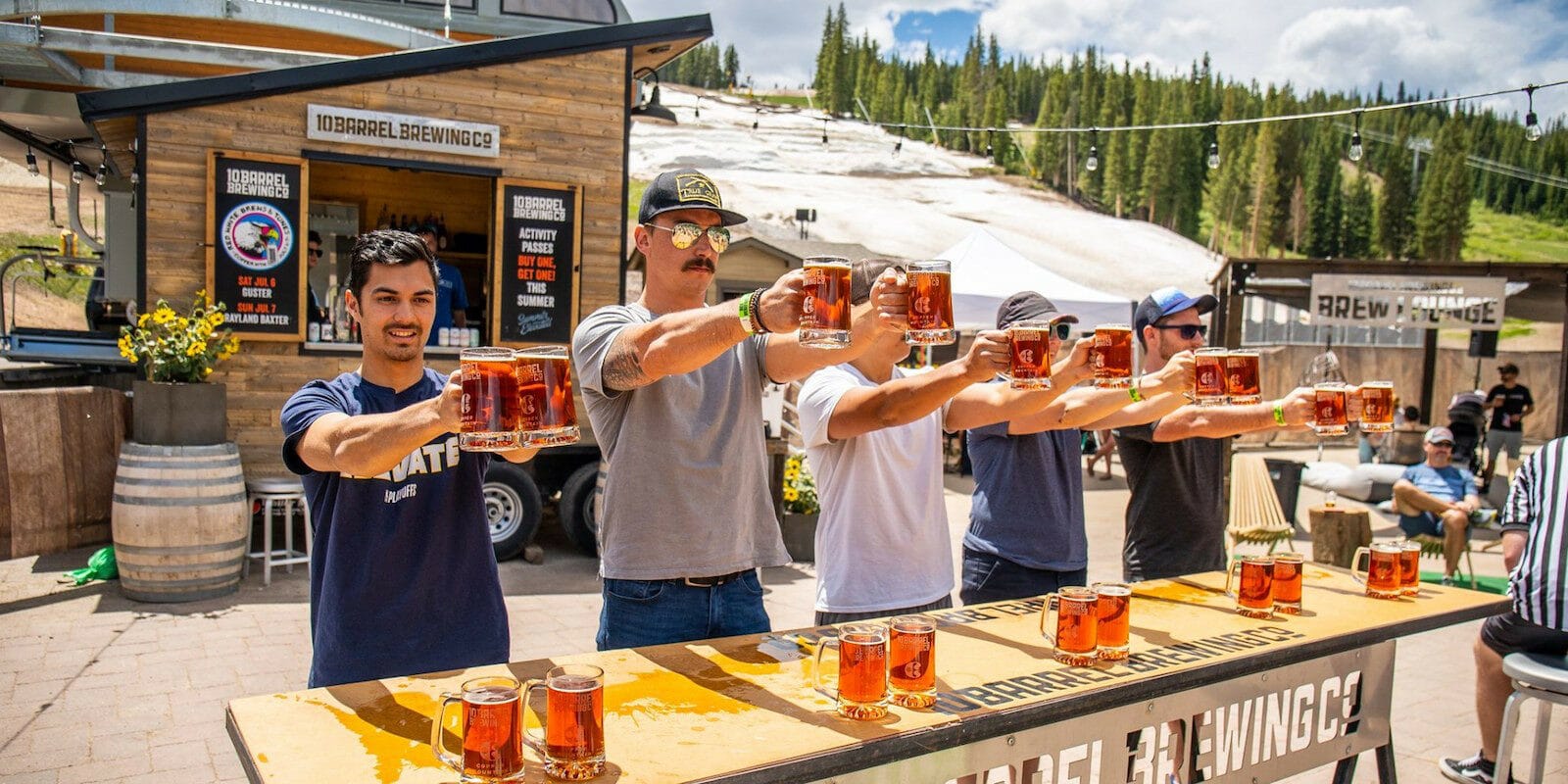 Image of people doing a stein hoist at the 10 Barrel Brewing Company booth at Brews and Tunes in Colorado