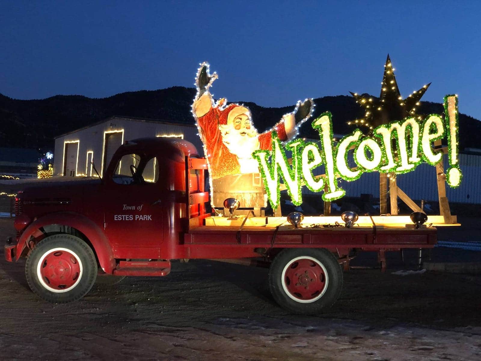 Image of a red trick with a light up santa welcome sign in Estes Park, Colorado