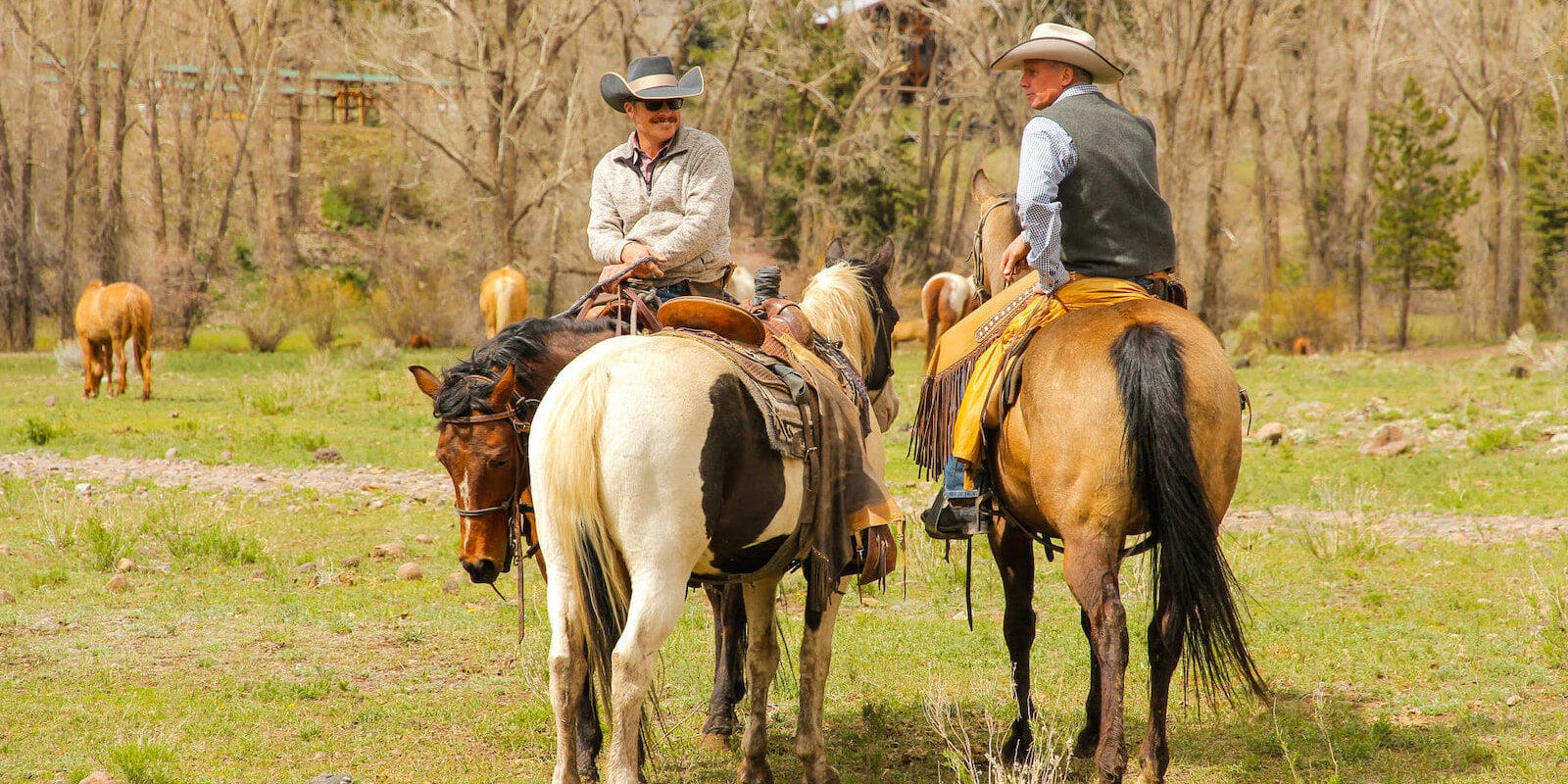 Image of two men riding horses at Rainbow Trout Ranch in Antonito, CO