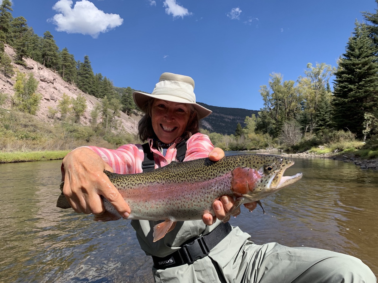 Image of a woman with a fish at Rainbow Trout Ranch in Antonito, CO