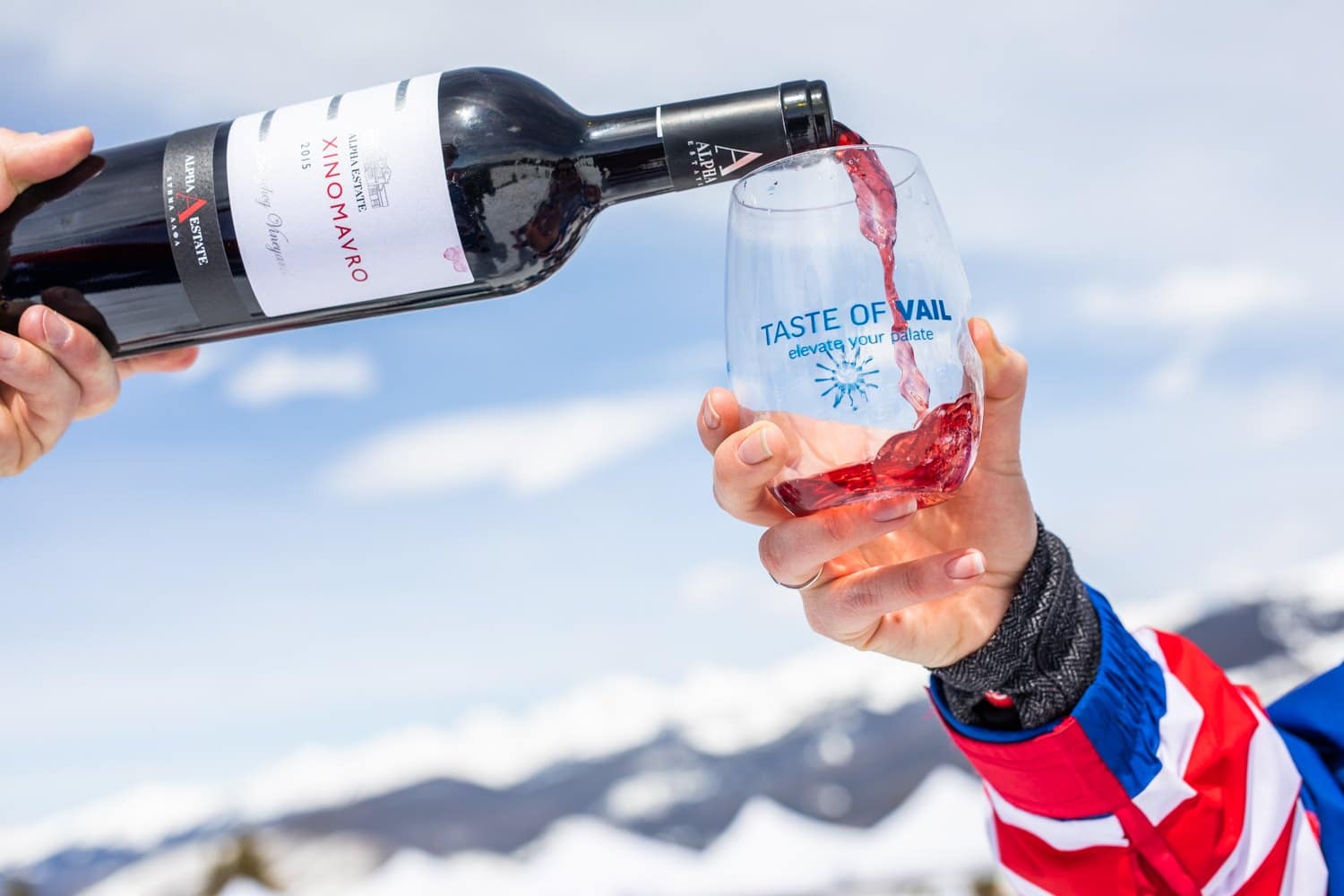 Image of a "Taste of Vail" wine glass being filled with red wine