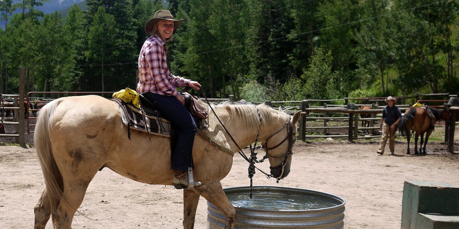 Image of a woman riding a horse at Tumbling River Ranch in Grant, Colorado