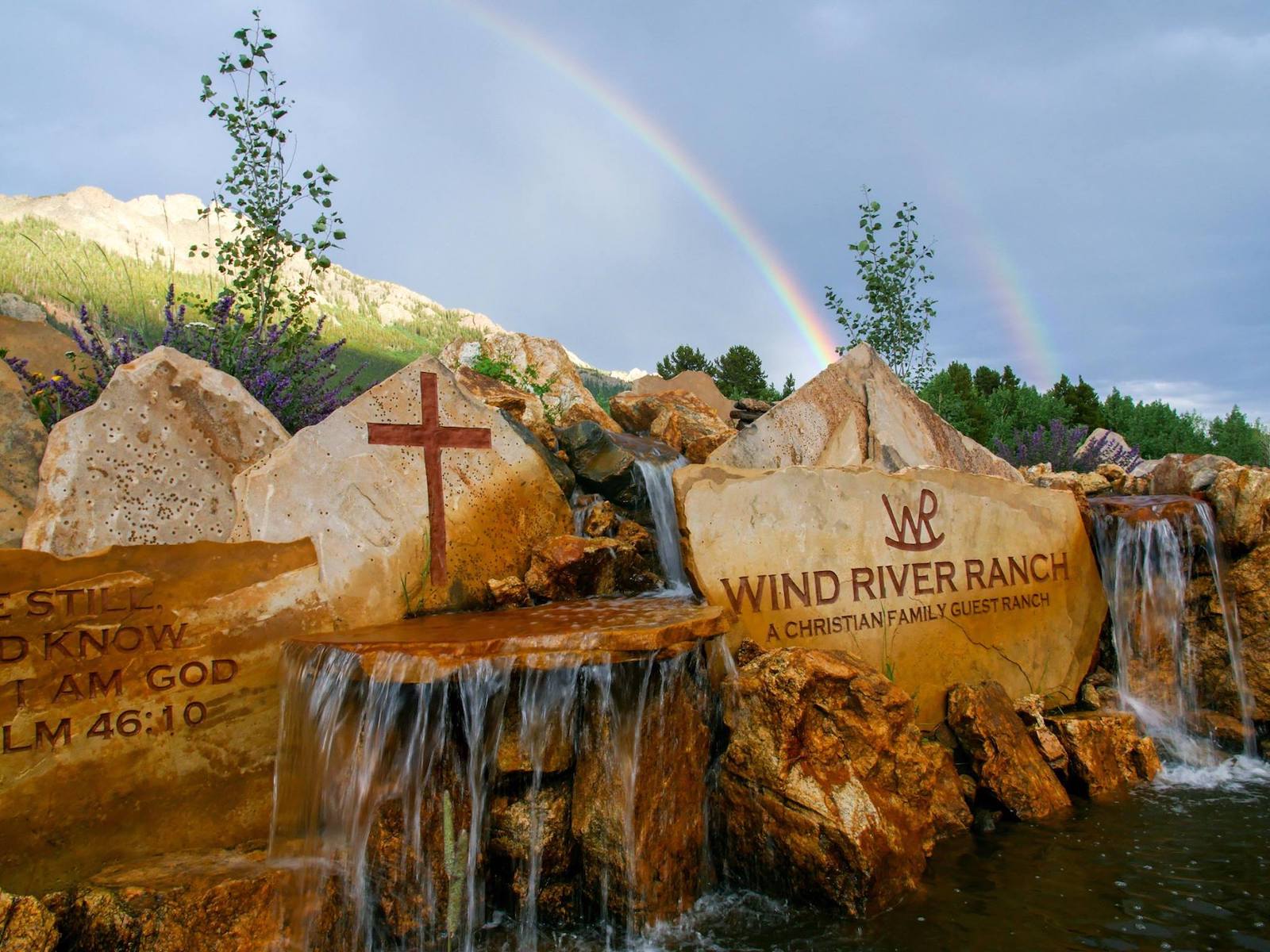 Image of the Wind River Ranch sign carved into a stone waterfall