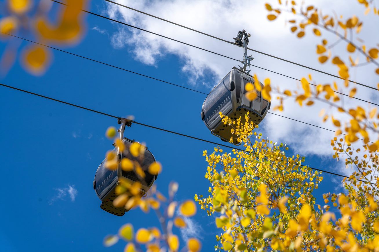 Image of the BreckConnect Gondola seen through the yellowing leaves in Breckenridge, Colorado