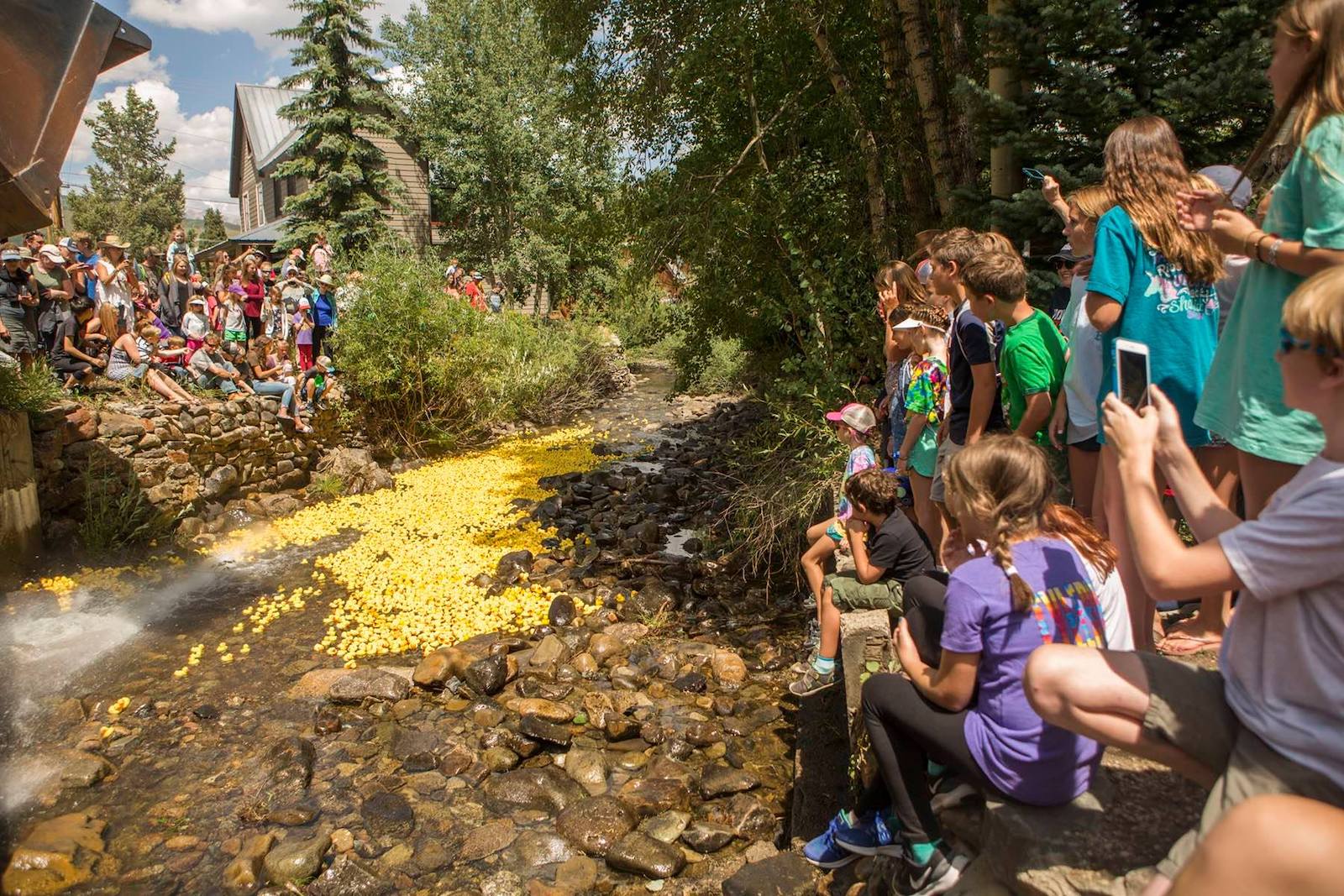 Image of people watching ducks being poured into the river at the Rubber Duck Race in Crested Butte, Colorado