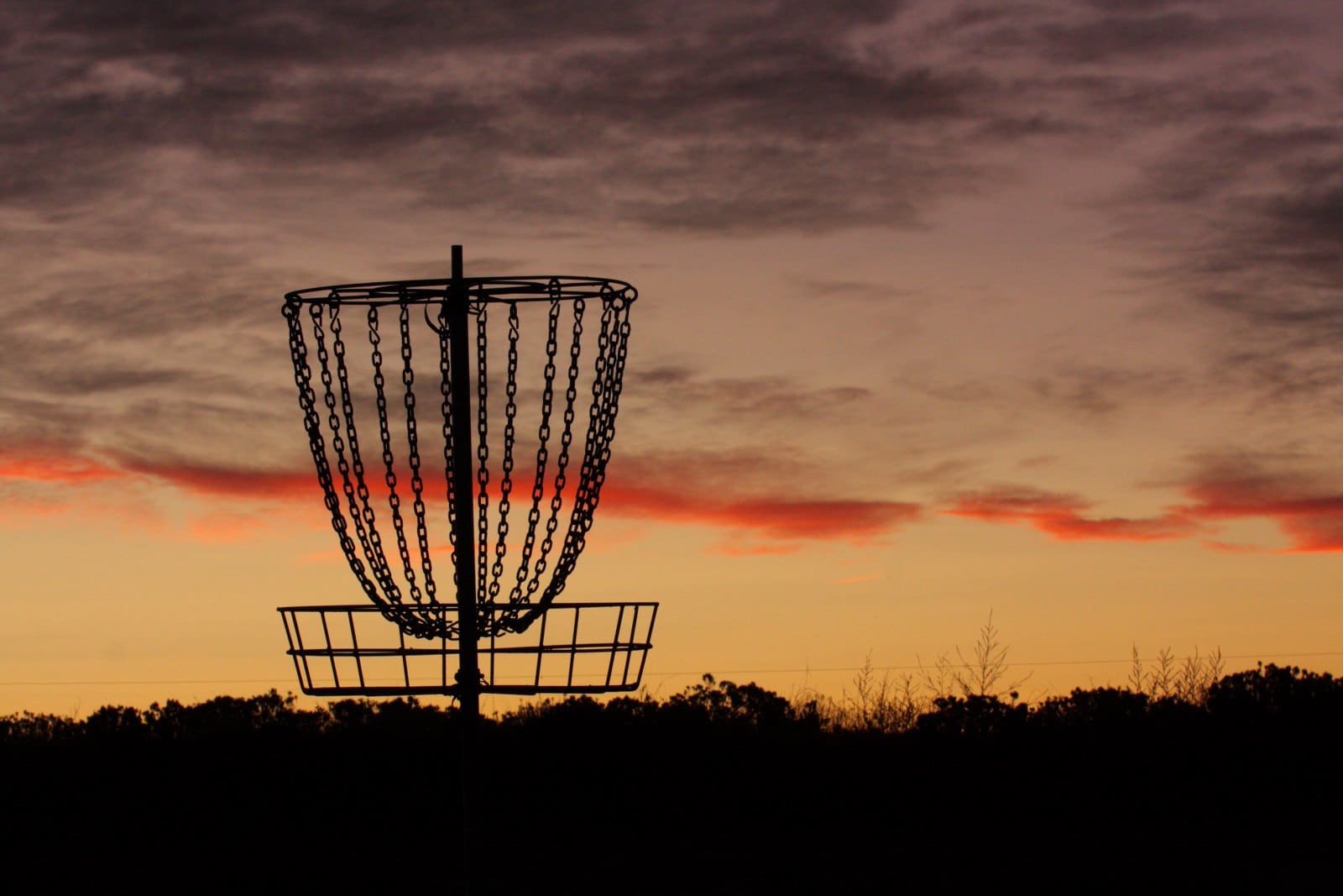 Image of a disc golf basket at sunset in Colorado