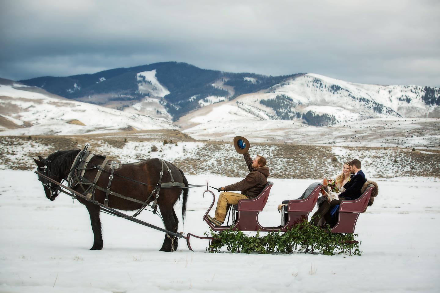 Image of people riding a sleigh in wedding attire at 4 Eagle Ranch in Wolcott, Colorado