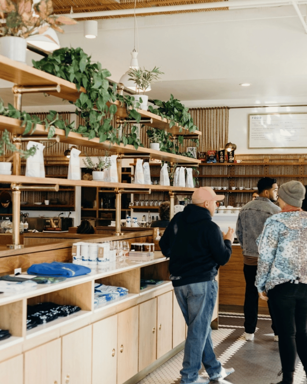 People waiting in line at a coffee shop next to a merchandise display