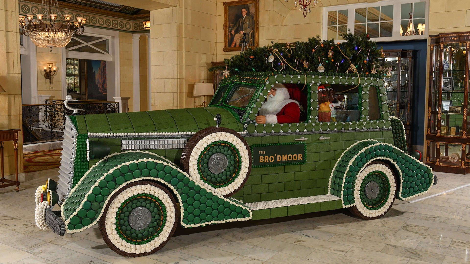 giant green car made out of candy and gingerbread in a hotel lobby