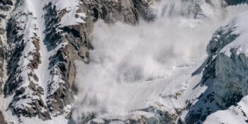 Active snow avalanche moving down mountain