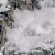 Active snow avalanche moving down mountain