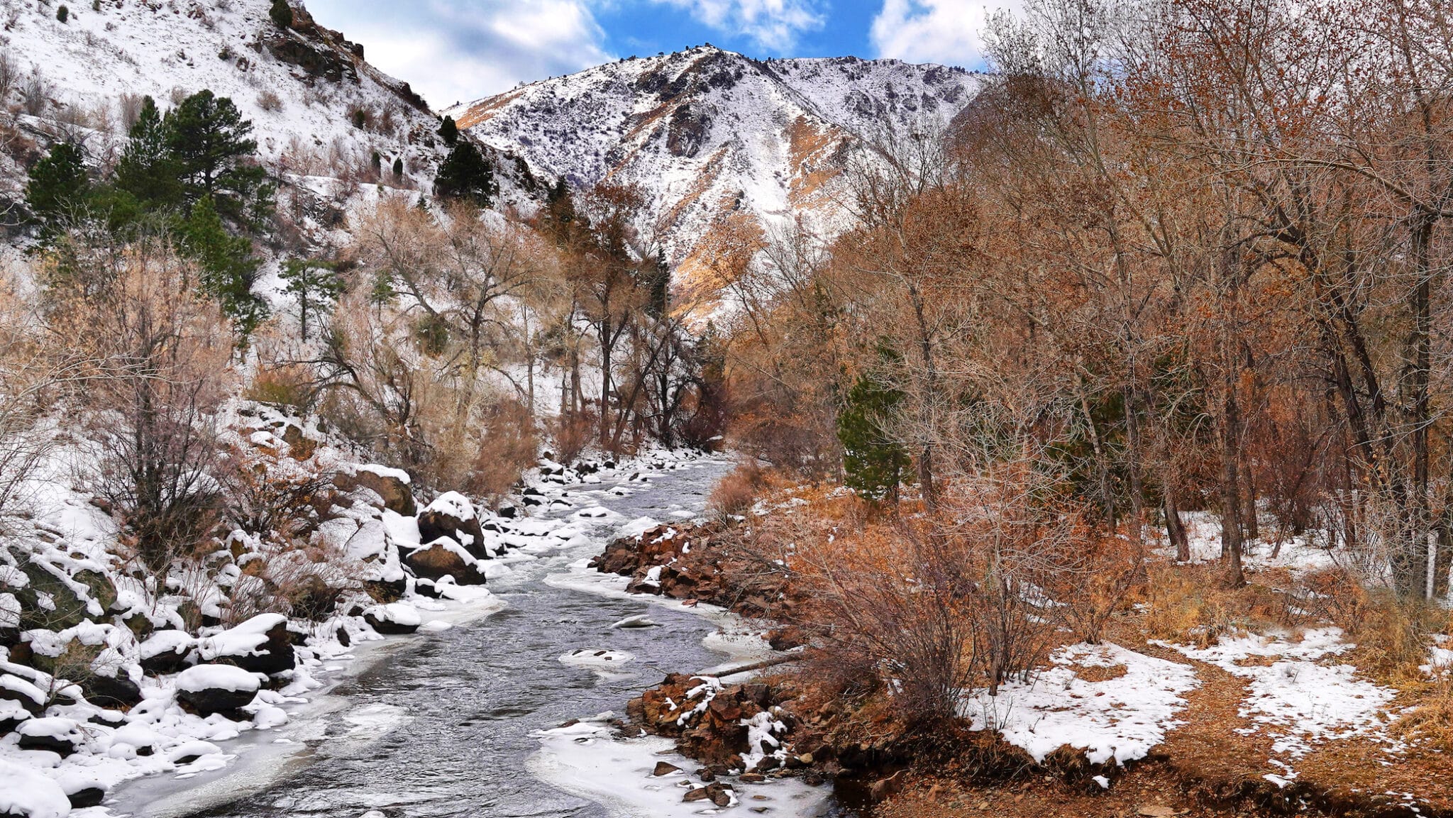 A thin layer of snow covers shady slopes along Clear Creek, Colorado in November