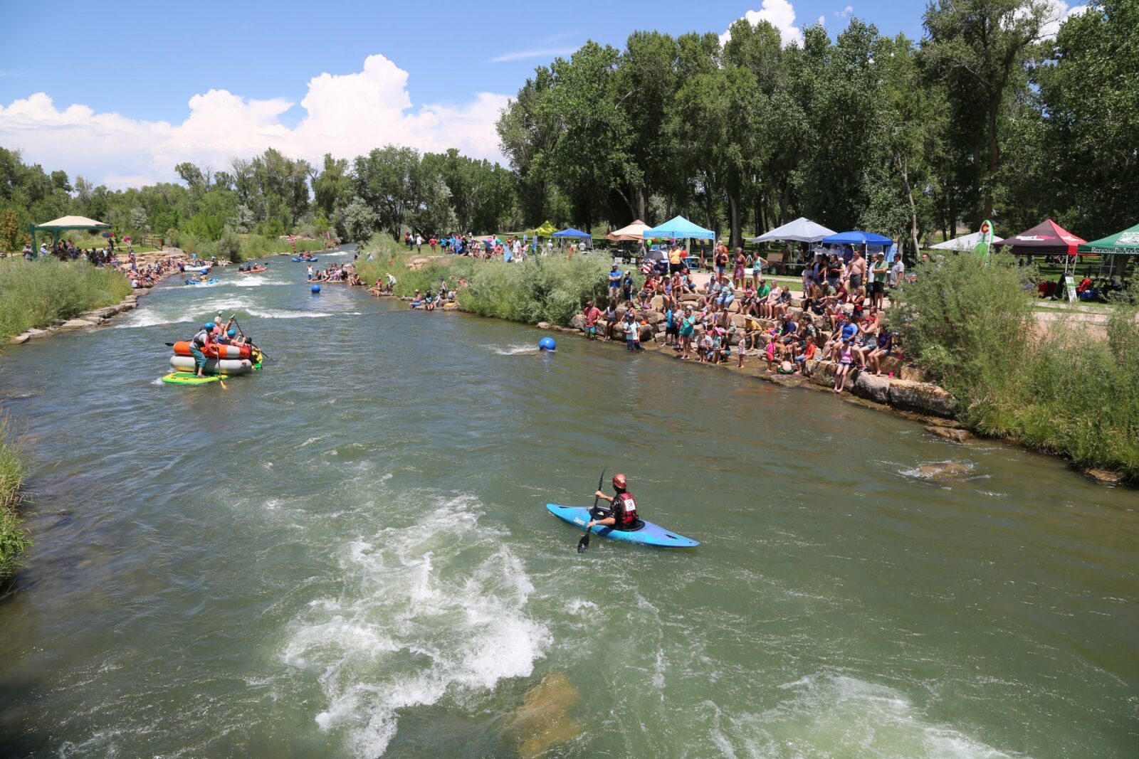 Image of rafters and kayakers in the river at Montrose Water Sports Park in Colorado