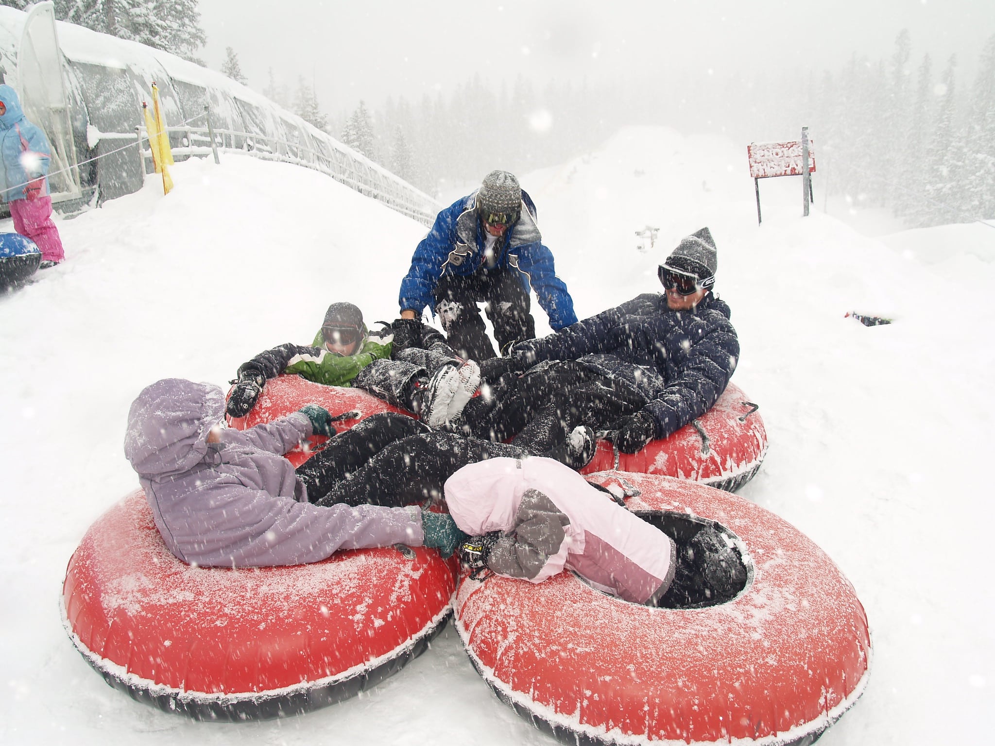 Family in snow tubes at the bottom of the hill