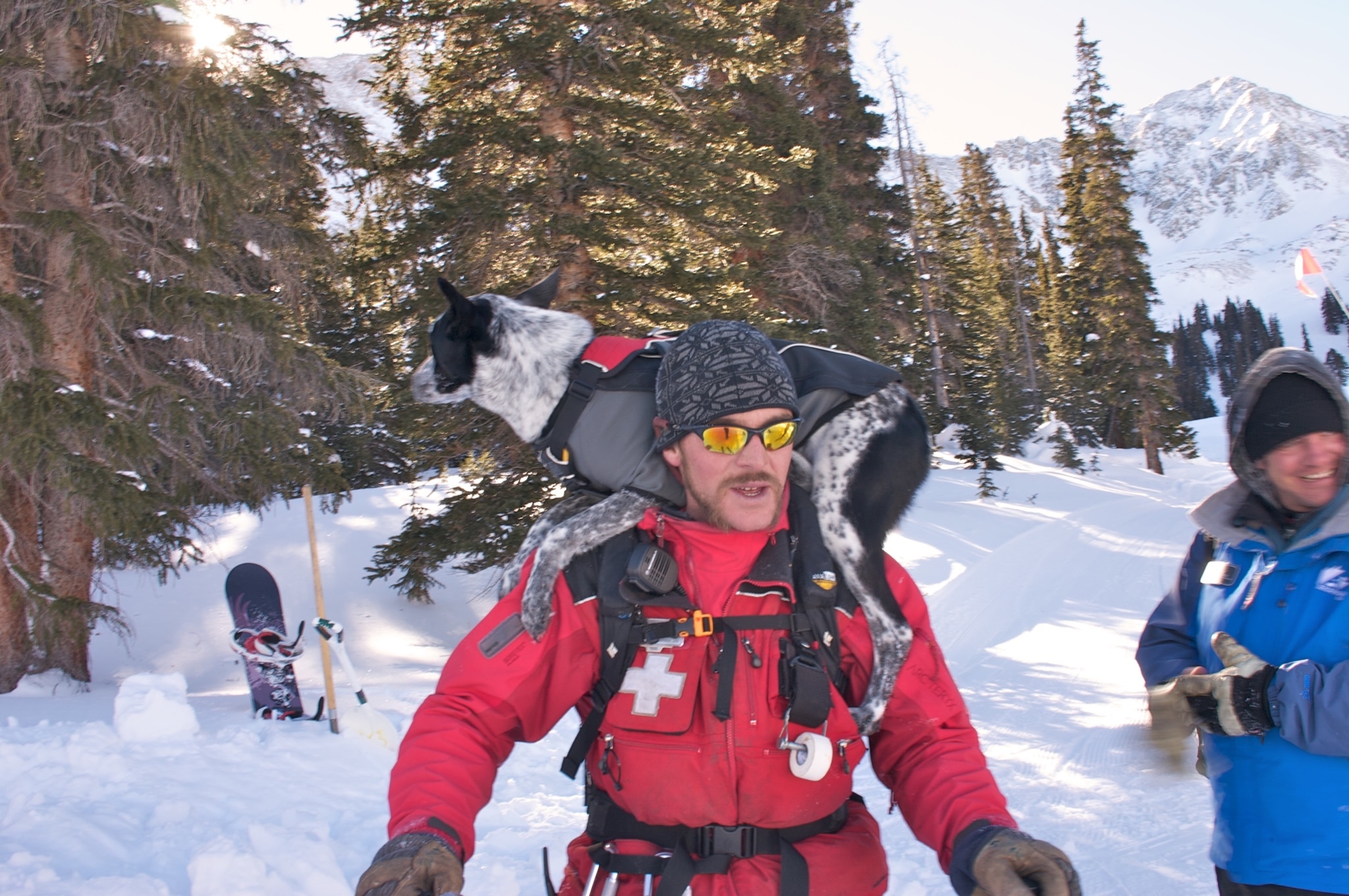 A ski patroller at Abasin with an avalanche recovery dog on his back.