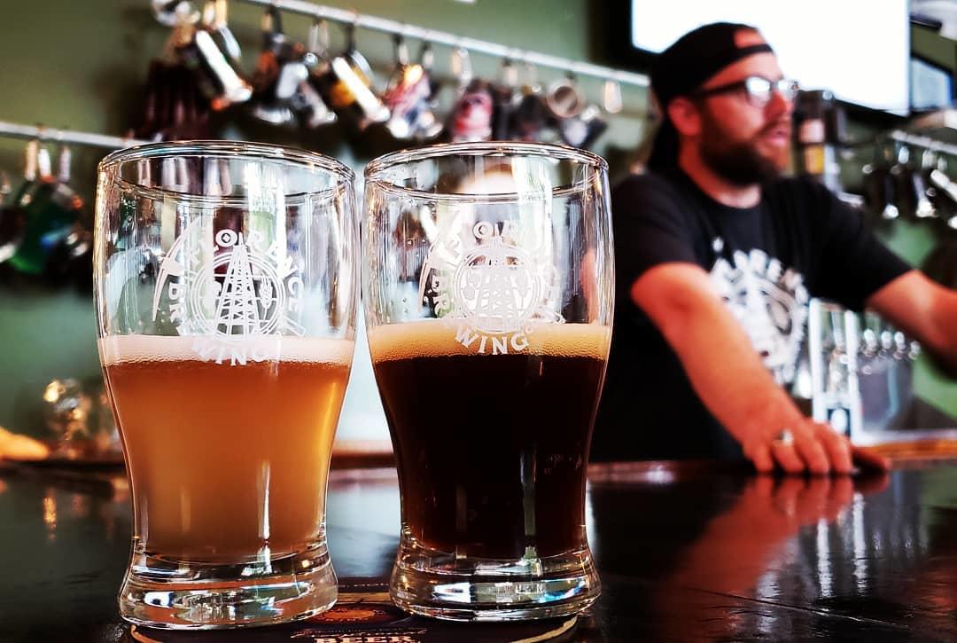 Two glasses of beer on a bar