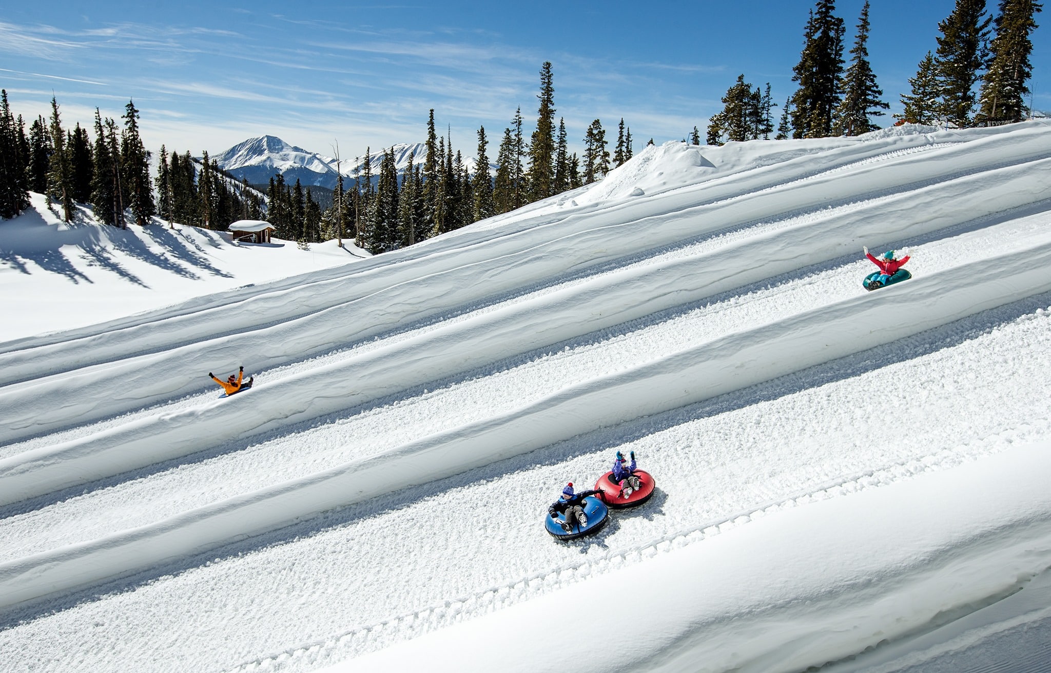 Steep snow tubing hill with riders going down