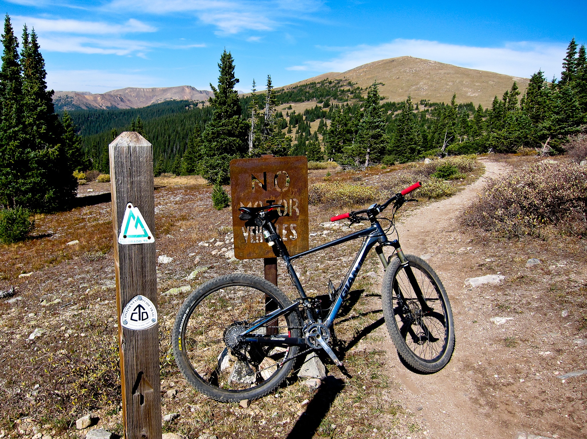 Mountain bike leaning against a no motor vehicles sign along the Colorado Trail.