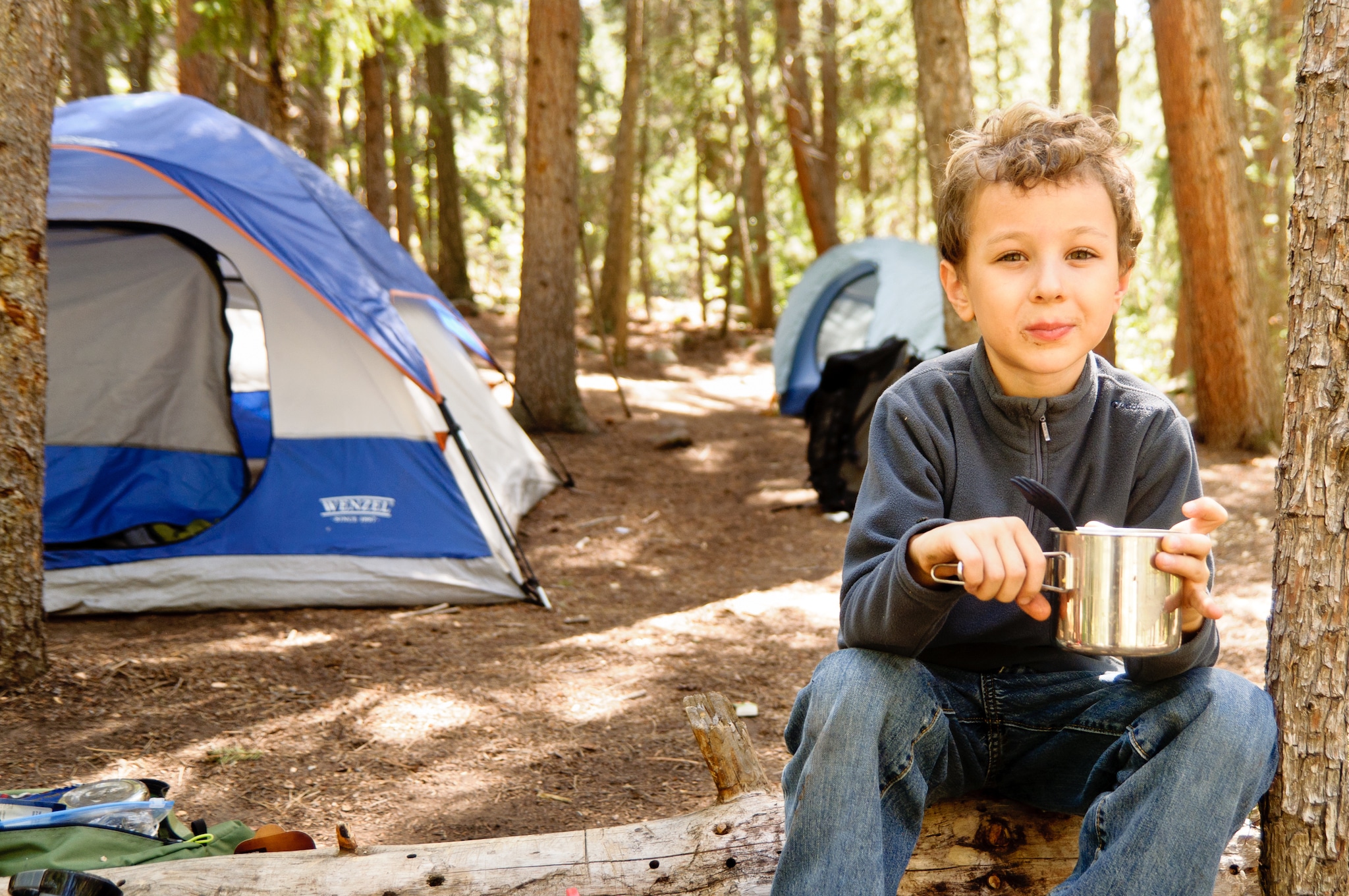 A happy young boy on a camping trip.