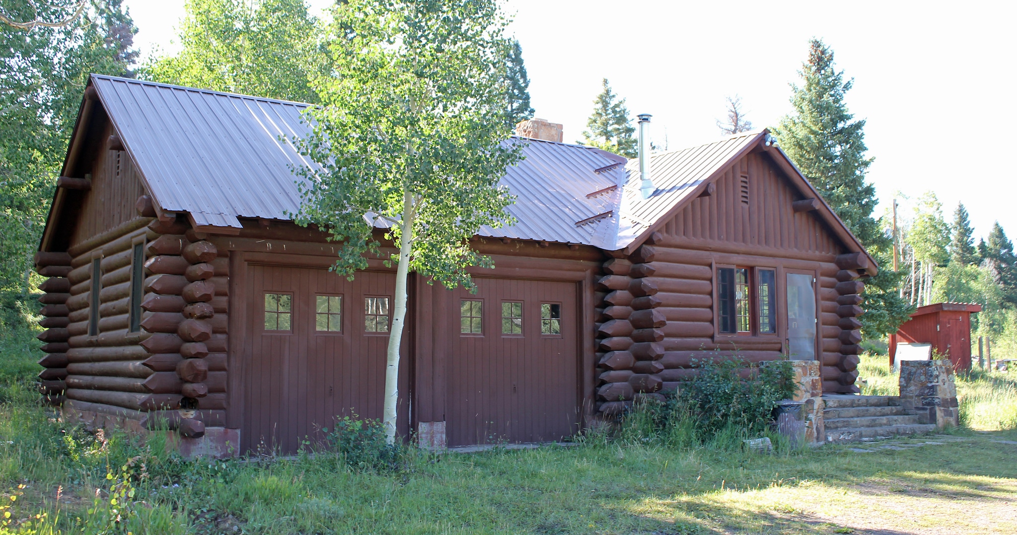 Looking at a refurbished USFS cabin for rent in a stand of aspen trees.