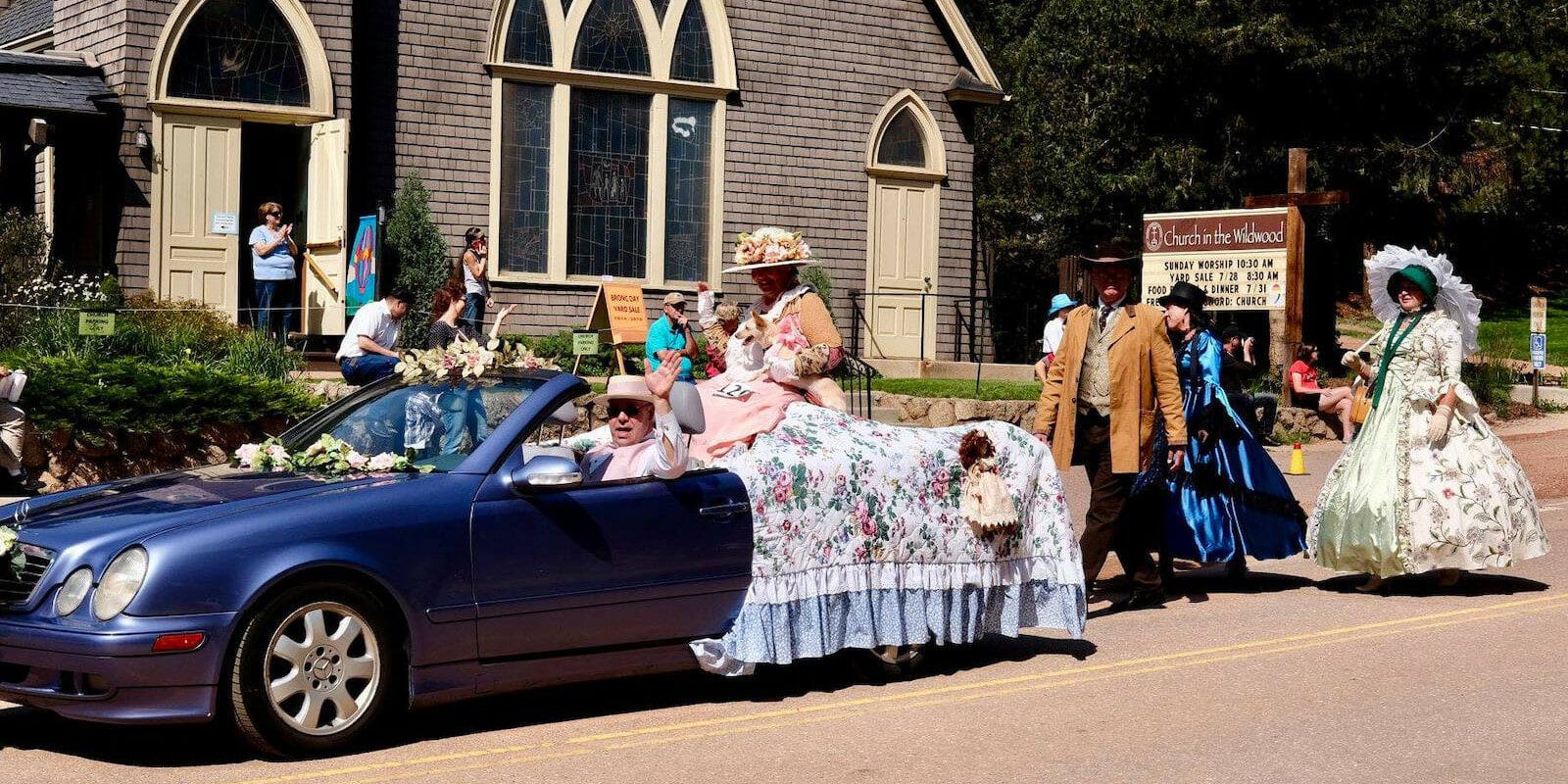 Image of people in a car in wild western attire at the Bronc Day Parade in Green Mountain Falls, Colorado