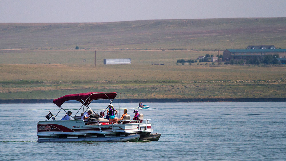 pontoon boat filled with people on a lake