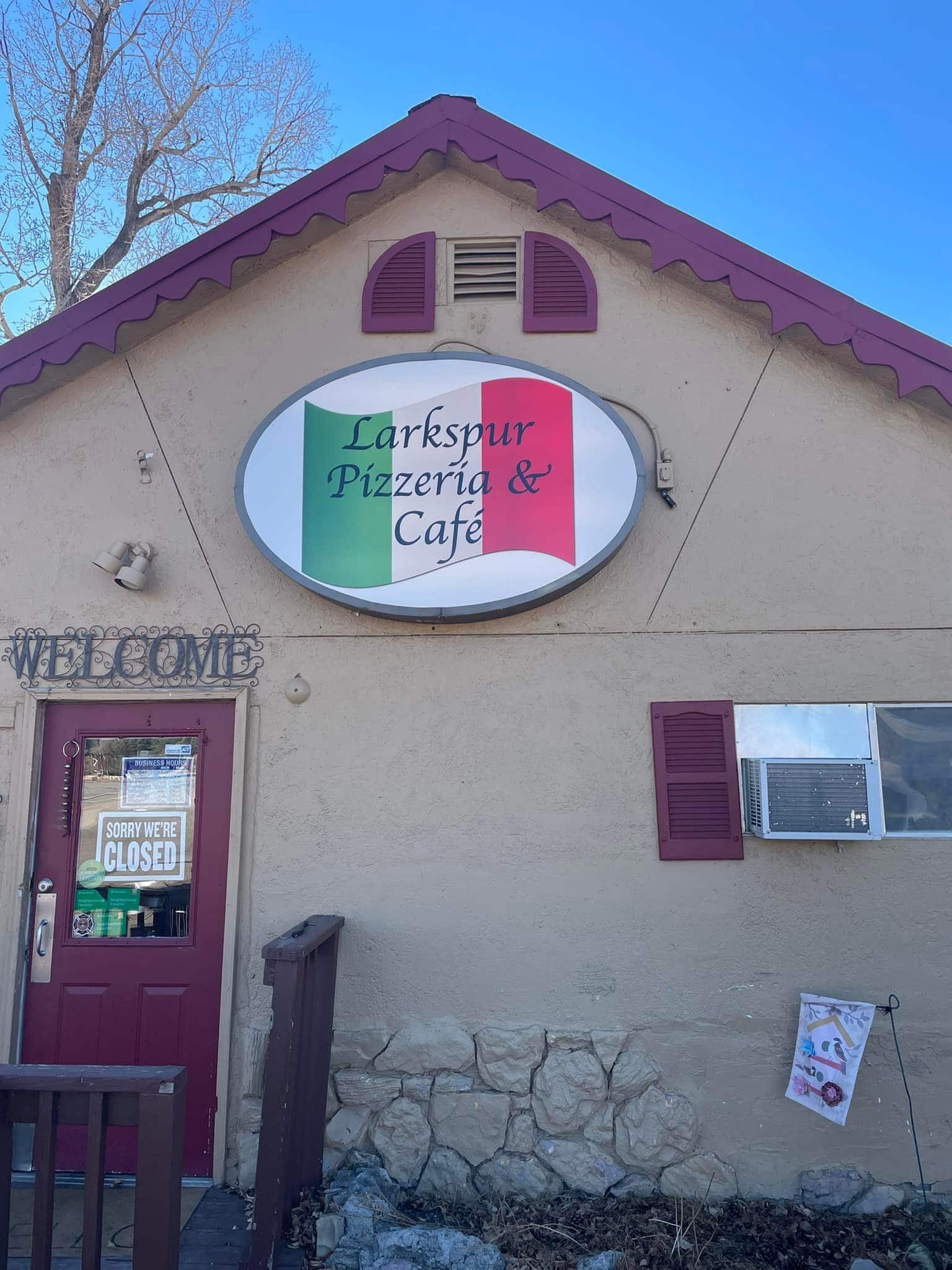 Tan building with Pizzeria sign