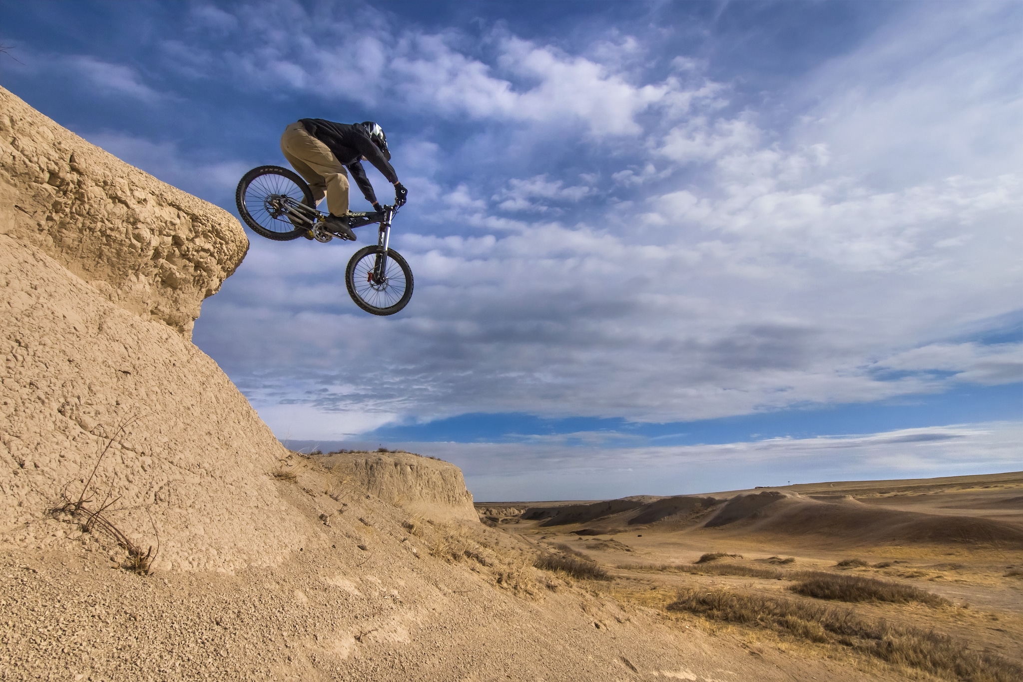 A mountain biker dropping a small sandstone cliff in Pawnee National Grassland.