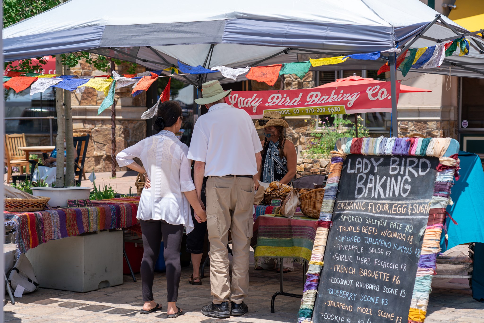 People looking at a booth at the farmer's market