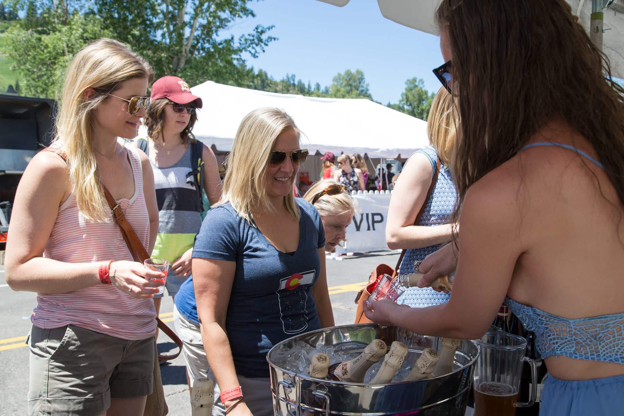 Dua pengunjung di festival Reds, Whites, & Brews di Steamboat Springs meminta sampel di salah satu tenda vendor